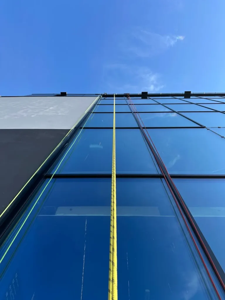 Großflächige Fassadenreinigung einer Fensterfront durch Seilzugangstechnik