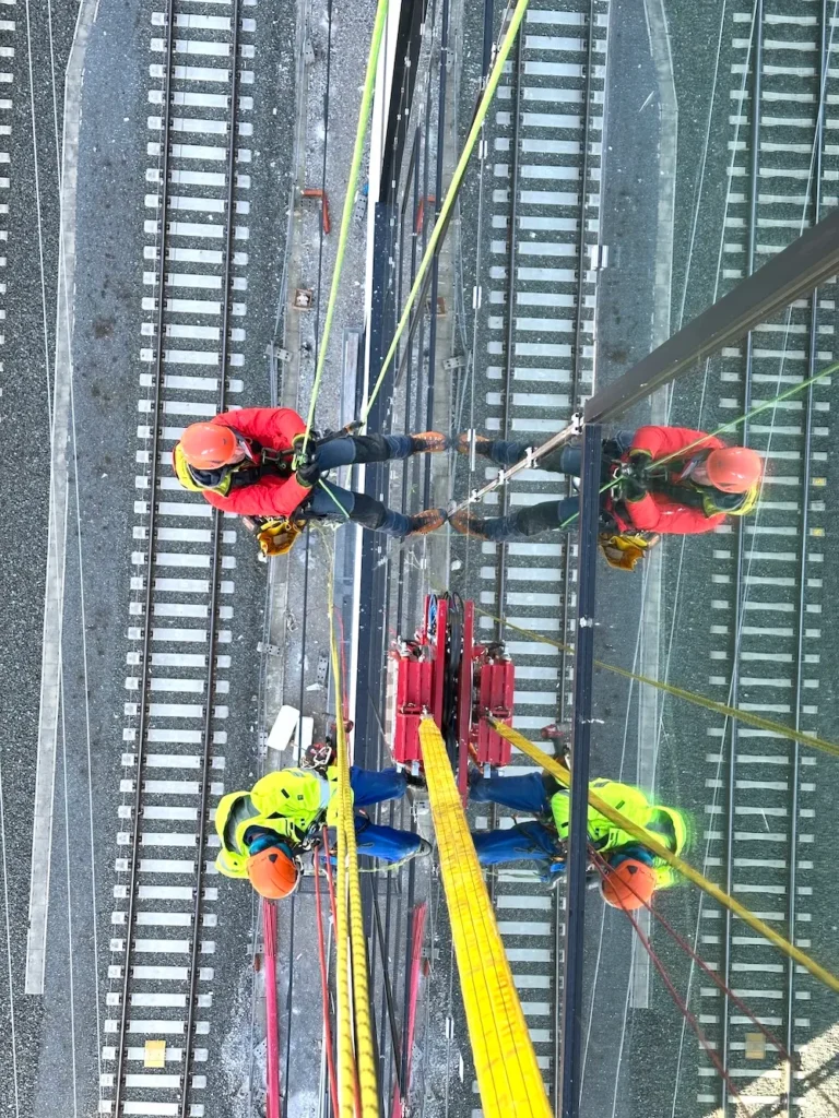 Industriekletterer bei Fassadenarbeiten mit Seilsicherung an modernem Gebäude